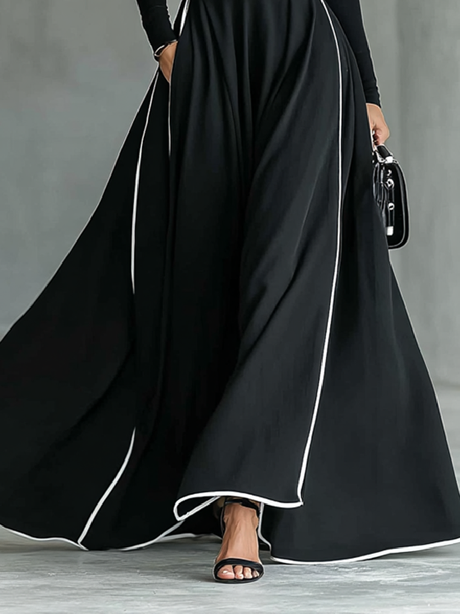 Robe maxi noire avec des coutures blanches, col haut, manches longues et taille cintrée