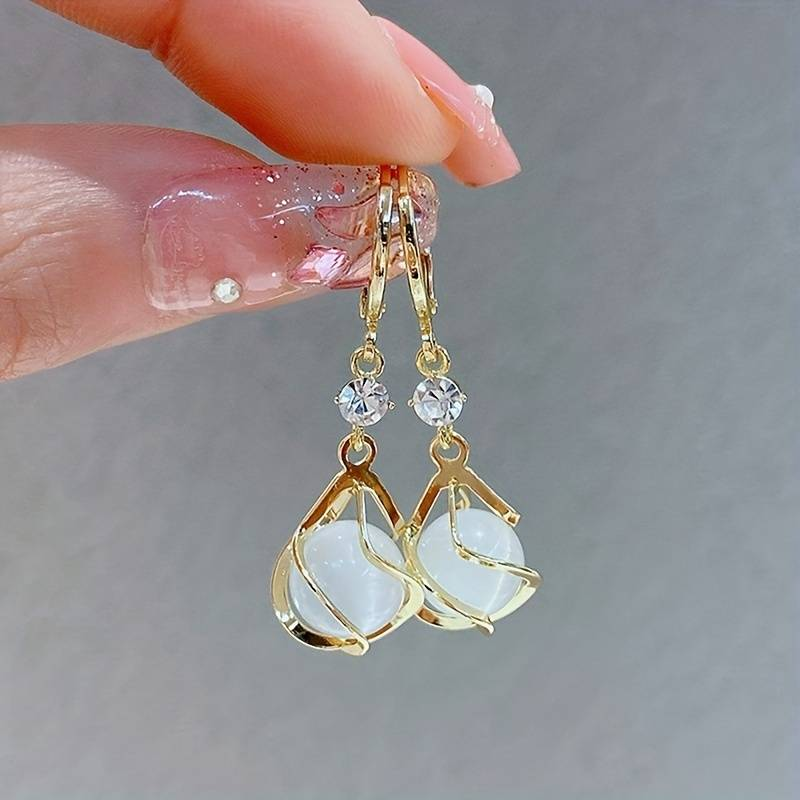 Boucles d'oreilles en or suspendues avec opale blanche